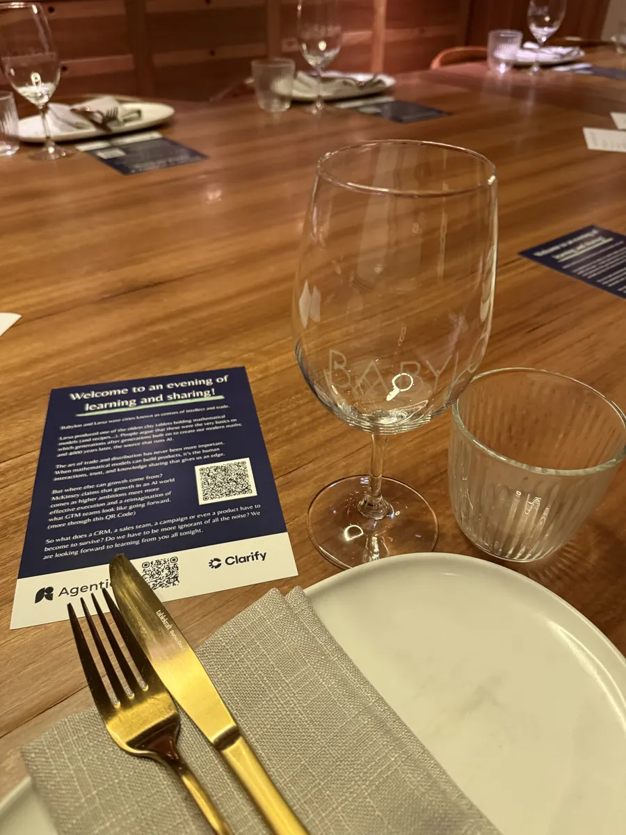 Table card welcoming guests to an evening of learning and sharing, with the Agentic and Clarify logos