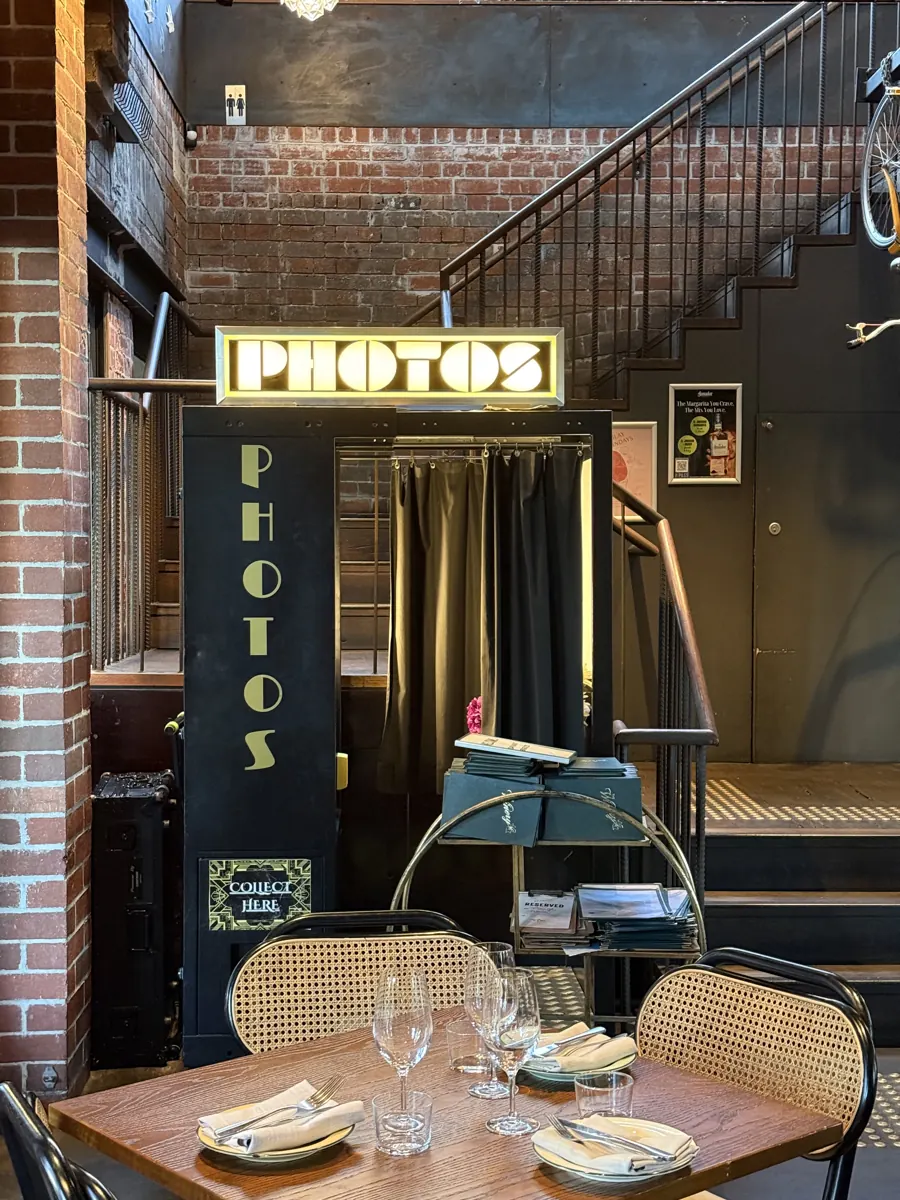 Table set beside a vintage photo booth at the venue