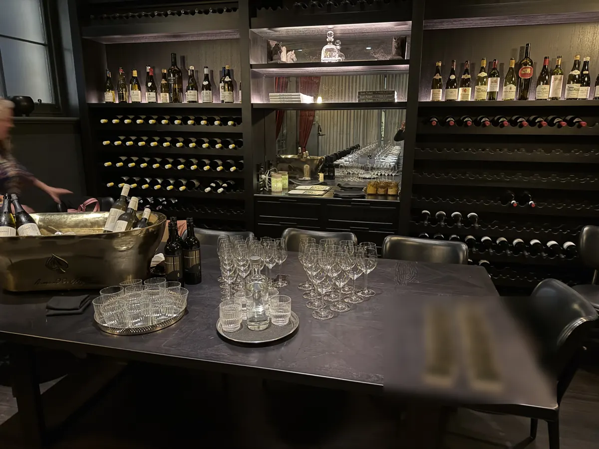 Glassware and place cards laid out in front of a wine wall before guests arrive